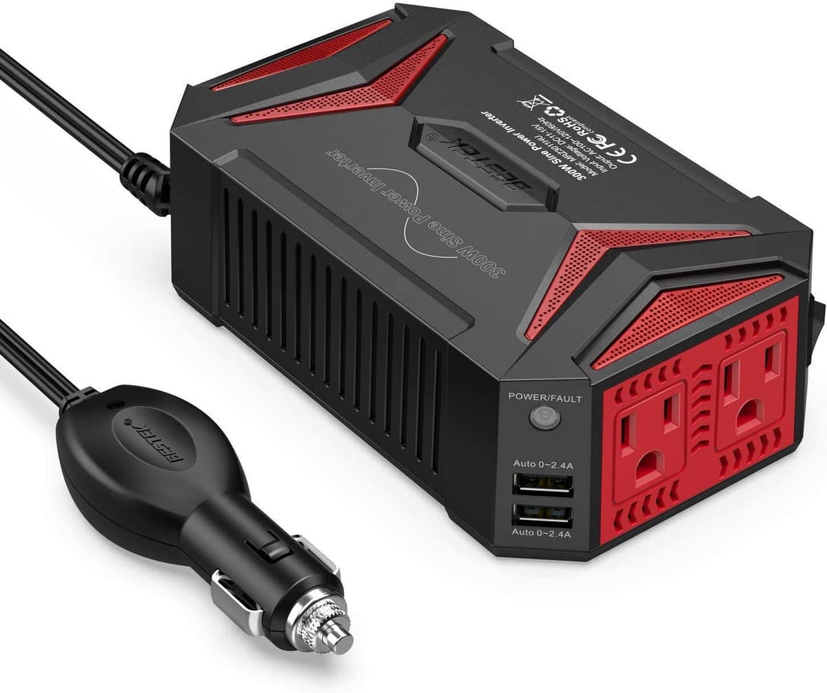 A red and black portable inverter with ports for household plugs and USB cables is connected to a 12V connector for vehicles.